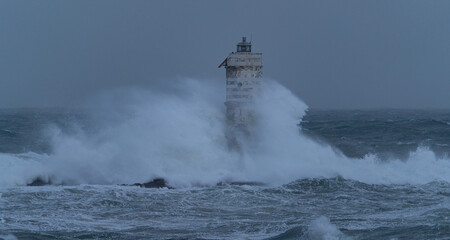 Powerful ocean waves smashing into isolated lighthouse during heavy sea storm