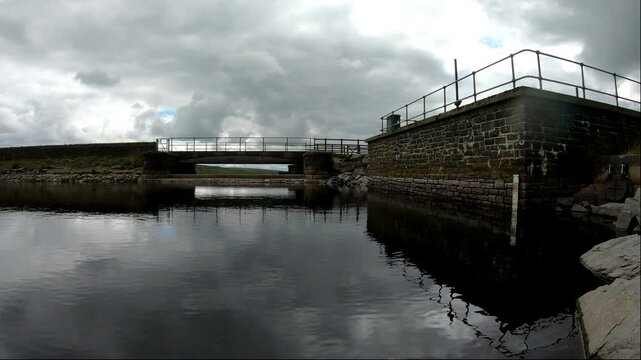 A peaceful calm view of Blackstone Edge Reservoir with the water level meter displayed on the wall.