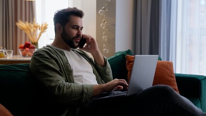 Fototapeta premium Happy smiling Caucasian business man bearded male guy client businessman homeowner freelancer worker talking mobile phone smartphone call working laptop typing computer freelance online work at home