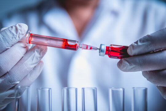 Doctor Prepares Syringe with Red Liquid from Vial, Blood Sample Preparation for Testing, Vaccine Preparation in Laboratory.