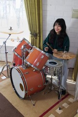 woman enjoys playing drums at home
