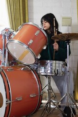 teenage girl practicing acoustic drums