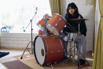 teenage girl practicing acoustic drums