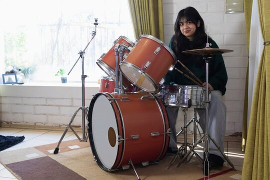 teenage girl practicing acoustic drums