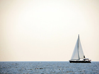 Sail Yacht Gliding Over Calm Sea Under Expansive Sky During a Serene Day