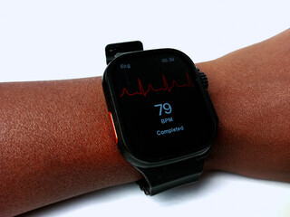African using smart watch to check BPM at home. Smart watch on the wrist displaying completed beats...