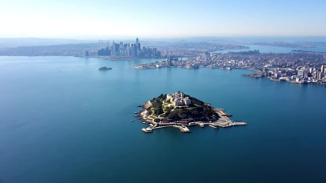An aerial view of Alcatraz Island revealing its isolation in the San Francisco Bay surrounded by water and the city skyline in