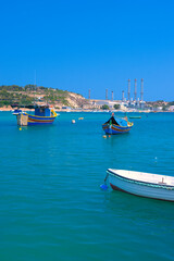 Fototapeta premium Malta Republic, Malta Island. 28. 06.2023. Marsaxlokk city, The harbor and colorated boats on a hot sunny day.
