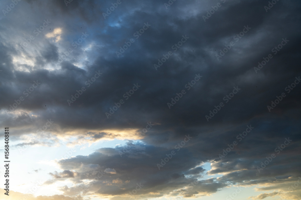 Wall mural beautiful sunset with evening clouds on dramatic sky.