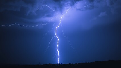 A dramatic lightning strike illuminates the dark stormy sky with electric blue brilliance.