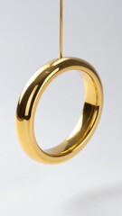 Gold Metal Ring Hanging Against White Background