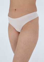 Beige women's briefs on the model. a woman in beige body shorts