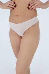 Beige women's briefs on the model. a woman in beige body shorts