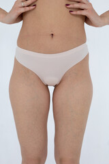 Beige women's briefs on the model. a woman in beige body shorts