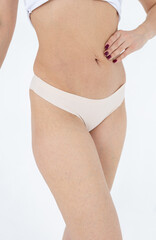 Beige women's briefs on the model. a woman in beige body shorts
