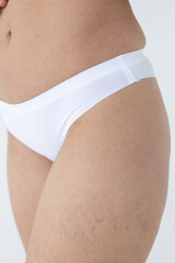 Beige women's briefs on the model. a woman in beige body shorts