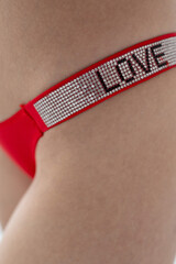 Red women's briefs on the model. young woman's body in red thong panties