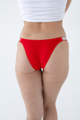 Red women's briefs on the model. young woman's body in red thong panties