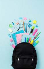 Colorful School Essentials Spilling from Backpack Top View