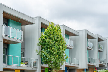 Fototapeta premium Top of modern apartment building with balcony, trees and beautiful landscape in Vancouver, Canada, North America. Day time on June 2025.