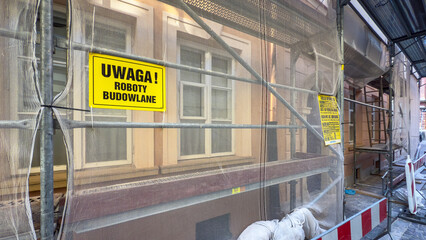 Rusztowanie metalowe, roboty na wysokości, remont elewacji, budynku, tablice ostrzegawcze, siatka ochronna.