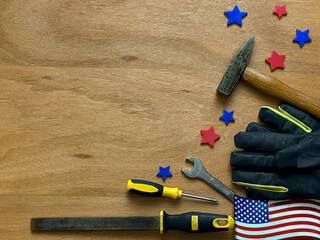 A mixed background for American Labor Day featuring tools like a hammer, wrench, screwdriver, and...