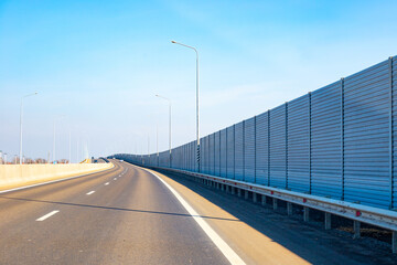 Anti-Noise screen along the road with moving transport. Noise protection fence preventing noise...