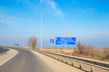 road with a sign indicating the direction of travel and trees on the side of the road