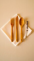 Flat lay of wooden cutlery set fork spoon knife on white napkin with lavender sprig on beige table