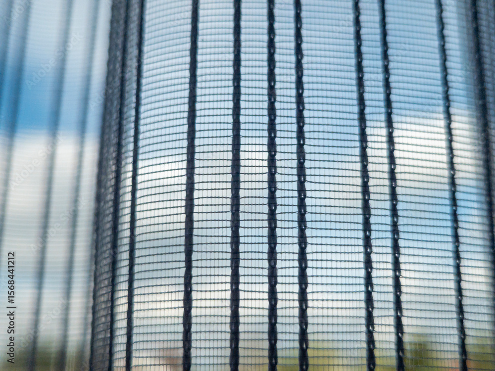 Poster close-up view of a mesh curtain with sunlight filtering through, casting soft shadows. the scene cap
