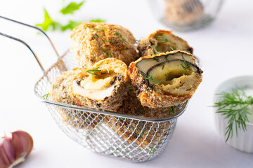 Crispy mushroom balls with cheese and spices baked in bread crumbs on on light kitchen table close up. Healthy homemade snack.