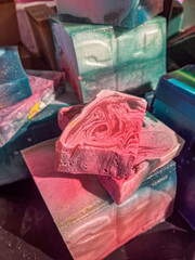 Handmade soap bars in vibrant colors, showcasing unique swirls and textures, arranged artistically...