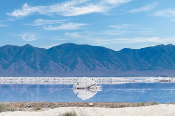 Panoramic view over a pink lake at Stansbury Island, Great Salt Lake, Utah, USA with mountains in background (pink color due to halophile microalgae and salt-loving bacteria)
