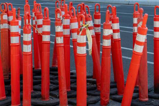  Large number of bright orange traffic delineator posts or traffic cones by the side of the road