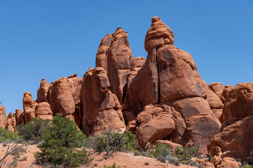 Landmark geological sandstone formation of Broken Arch against a blue sky in Arches National Park, Moab, UT, USA