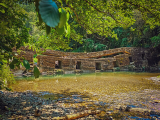 collapsed old dam in a water stream 