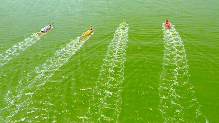 Aerial view of the rougher competition between the teams on rowing boats on the pond.