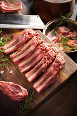 Fresh Raw Lamb Ribs on Wooden Cutting Board with Herbs