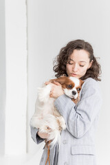 a woman holds a King Charles spaniel in her arms