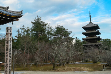 Iconic five-story pagoda of Ninna-ji Temple rises above winter trees in classic landscape view,...