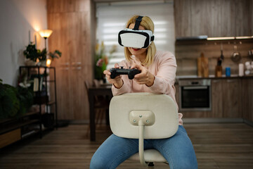Virtual reality adventure unfolds in a cozy modern kitchen as a young woman immerses herself in gaming excitement and exploration
