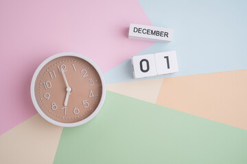 December 1st. Wooden calendar with the date December 31 and a clock on a colored background with...