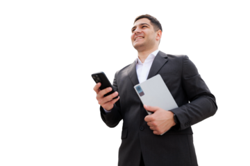 Business professional smiles confidently while holding a laptop and smartphone against a clean background, showcasing modern work culture