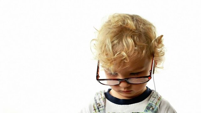 Little blond boy with smartphone and glassed on white background 