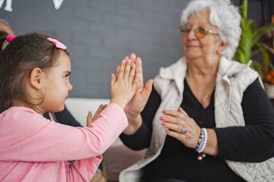 Joyful clapping game with grandma and granddaughter
