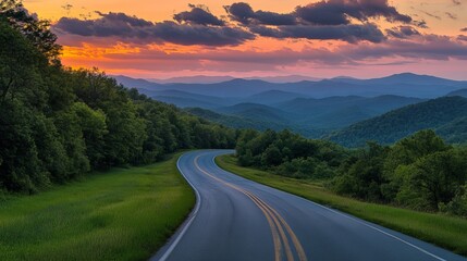 A paved road runs through green mountains under a cloudy sunset sky. A scenic outdoor road view.
