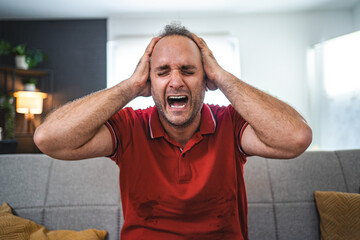 Man sitting alone at home looking sad and distraught