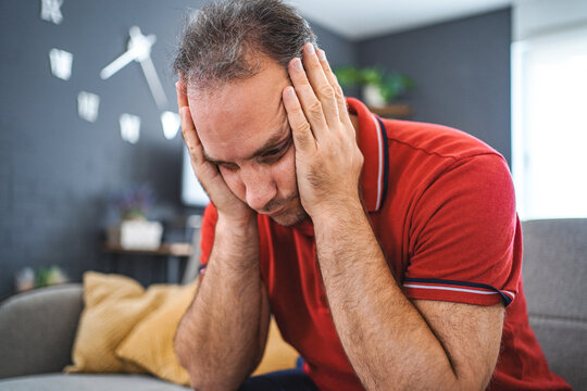 Man sitting alone at home looking sad and distraught