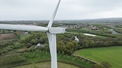 Wind turbines stand tall in a green field, symbolizing clean, sustainable power production, East Sussex, UK