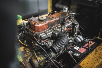 Detailed view of a vintage engine, highlighting the rusty exhaust system and mechanical parts.